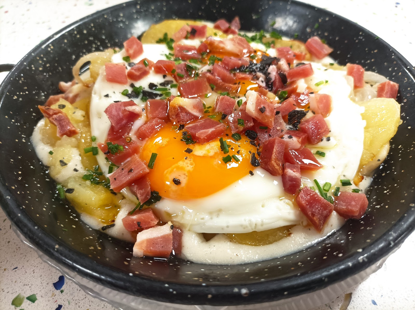 Huevos estrellados con jamón sobre patatas