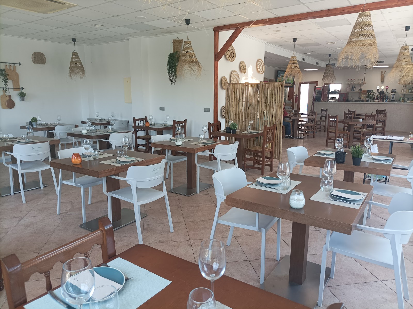 Comedor de Espai Mediterrani, con lámparas de fibra natural y mesas de madera